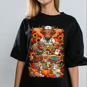 Puede incluir: Una camiseta negra con un estampado gráfico de ganado Highland y otros animales vestidos de veterinarios. El diseño incluye girasoles, hojas de otoño, calabazas, herramientas médicas, un libro médico y un cartel que dice get well soon.