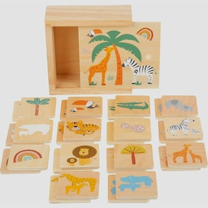 Peut inclure: Jeu d'association d'animaux en bois avec une boîte en bois. La boîte présente une girafe et un zèbre sous un palmier. Le jeu comprend des tuiles en bois avec des illustrations colorées de divers animaux, dont un lion, un tigre et un éléphant.