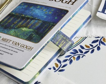 Peut inclure: Un carnet sur le thème de Van Gogh avec une peinture de nuit étoilée sur la couverture. Le carnet a des pages lignées et une sangle en cuir bleu. Le texte "VAN GOGH" est imprimé sur la couverture.