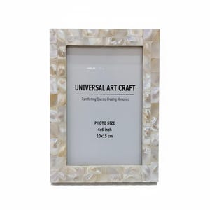 Könnte beinhalten: Rechteckiger Fotorahmen mit Mosaikdesign. Der Rahmen besteht aus kleinen, quadratischen, cremefarbenen Teilen. Der Text "UNIVERSAL ART CRAFT" ist oben aufgedruckt, darunter "Transforming Spaces, Creating Memories". Fotoformat 10x15 cm.