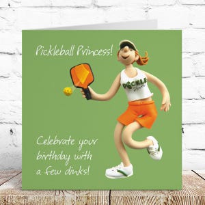 May include: A square greeting card with a green background featuring a cartoon figure playing pickleball. The figure wears a white tank top with the text Pickle Power and orange shorts. Text reads Pickleball Princess! Celebrate your birthday with a few dinks!