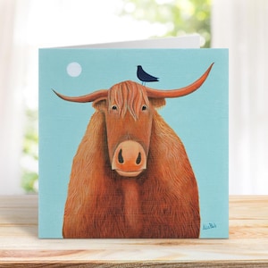 May include: Square greeting card with a Highland cow illustration. The cow has long, shaggy, reddish-brown fur, large horns, and a small black bird on its head. The background is a light blue with a white circle representing the sun.