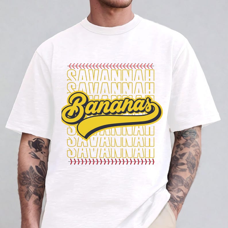 May include: White t-shirt featuring the text "Savannah Bananas" in yellow and black, with a baseball stitch design. The word "Savannah" is repeated in a vertical pattern.
