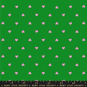 Puede incluir: Tela verde con un patrón repetitivo de pequeños corazones rosas. Los corazones están espaciados uniformemente en la superficie. El texto "RUBY STAR SOCIETY" está impreso en la parte inferior.