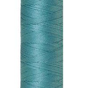 Op de afbeelding: Een spoel van turquoise zijden draad. De draad is strak gewikkeld rond een cilindrische kern. De boven- en onderkant van de spoel zijn lichtpaars, met de merknaam "Mettler Silk-" bovenaan.