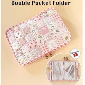 May include: A rectangular double pocket folder featuring a patchwork exterior of pink and white floral, strawberry, and gingham fabric squares. The folder has a pink and white checkered trim and two metal zippers. The interior shows mesh pockets.