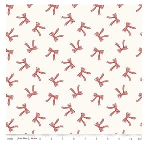 May include: Cream-colored fabric with a repeating pattern of red bows. The bows are evenly spaced across the fabric, creating a visually appealing design. The fabric has a ruler along the bottom edge, marked in inches.