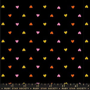 Op de afbeelding: Zwarte stof met een herhalend patroon van kleine gele, oranje en roze hartjes. De hartjes zijn gelijkmatig verdeeld. De tekst "RUBY STAR SOCIETY" staat onderaan.