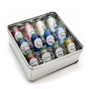 May include: A rectangular silver metal tin containing twelve spools of Isacord 40 embroidery thread in various colors including pink, blue, green, gold, and white. Each spool features a white label with black text and a barcode.