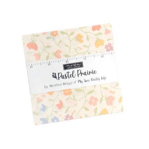 May include: A stack of fabric squares with a floral pattern in pastel colors. The fabric is cream-colored with orange, pink, and purple flowers and green stems. The label reads "Pastel Prairie" by Heather Briggs of My Sew Quilty Life.