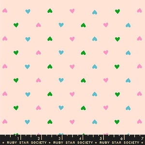 May include: A fabric with a repeating pattern of small hearts in green, pink, and blue on a light peach background. The hearts are evenly spaced across the fabric. The text "RUBY STAR SOCIETY" is at the bottom.