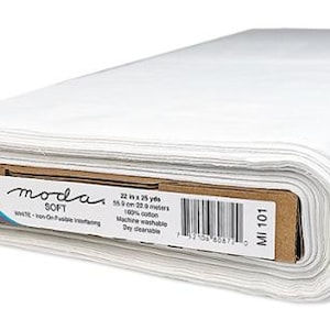 May include: A roll of white Moda Soft fabric. The label indicates the fabric is 55.9 cm by 22.9 meters, 100% cotton, and machine washable. The fabric is iron-on fusible interfacing.