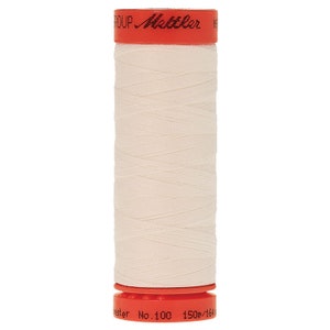 May include: A spool of white thread with an orange label that reads "GROUP - Mettler - Polyester No. 100 150m/164yd".