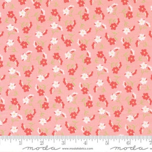 May include: A floral fabric with a repeating pattern of small red and white flowers on a light pink background. The flowers are arranged in a scattered design with green stems and leaves. The fabric is marked with a ruler.
