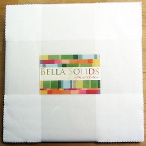 May include: A package of white fabric squares labeled "Bella Solids" with a colorful striped design on the label.