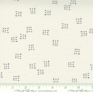 May include: White fabric with a repeating pattern of small gray squares and triangles. The fabric is marked with a ruler in inches.