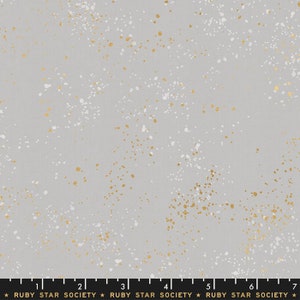 Peut inclure: Un tissu gris avec un motif moucheté de points blancs et dorés. Le tissu est un mélange de coton et est parfait pour le quilting, la couture et l'artisanat.