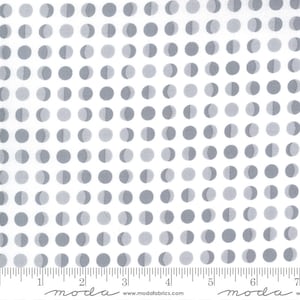 May include: White fabric with a repeating pattern of gray half-moon circles. The fabric is marked with a ruler in inches and the words "moda" and "www.modafabrics.com".