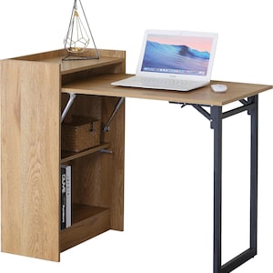 May include: A light brown wooden desk with a fold-out tabletop and a built-in storage unit. The desk has a black metal frame. A laptop and mouse are on the tabletop. A geometric candle holder sits on top of the storage unit. The desk is 100 cm wide.