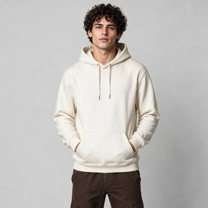 Puede incluir: Una sudadera con capucha de color crema de manga larga que presenta un bolsillo tipo canguro frontal y cordones ajustables a juego en el cuello. La prenda cuenta con puños y dobladillo acanalados para ofrecer un ajuste estructurado.
