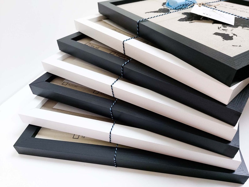 May include: A stack of six picture frames, alternating between black and white frames. The frames are made of wood and have a simple, modern design.