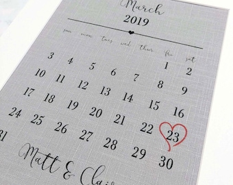 Puede incluir: Un calendario gris con el mes de marzo de 2019 impreso en él. El 23 está resaltado con un corazón rojo. Los nombres Matt & Claire están impresos en la parte inferior.