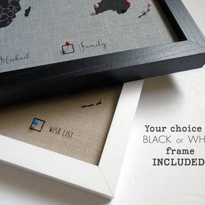May include: A framed world map with push pins marking locations. The map is on a linen background and has a black frame. The text "Wish List" is written on the map. The text "Your choice of BLACK or WHITE frame INCLUDED!" is written below the map.