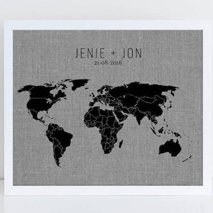 May include: A black and white world map print on a gray linen background with the text "JENIE + JON 21-08-2016" above the map.