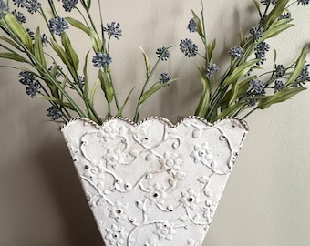 Maceta vintage de metal blanco con relieve floral.