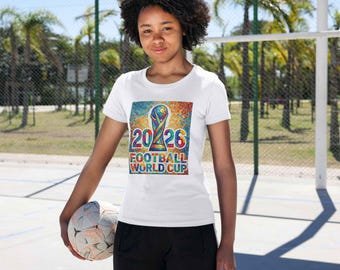 May include: White t-shirt with a colorful graphic featuring the text "2026 FOOTBALL WORLD CUP" and a trophy design. The shirt is worn by a person holding a soccer ball. The background includes palm trees and a sports court.