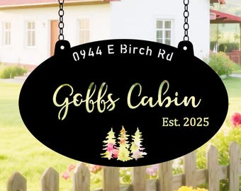 May include: Black oval metal sign with the text "Goffs Cabin" and "Est. 2025" in a cursive font. The sign also includes the address "0944 E Birch Rd" and a watercolor image of three trees. The sign hangs from two chains.