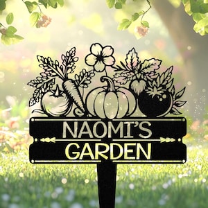 Pode incluir: Estaca de jardim de metal preto com um topo decorativo com desenhos recortados de vegetais e flores. A estaca exibe as palavras "NAOMI'S GARDEN" em branco. O design inclui uma cenoura, uma abóbora e tomates.