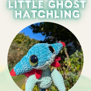 Op de afbeelding: Een gehaakte Little Ghost Hatchling in blauw en rood. Het knuffel heeft grote, ronde ogen en een fuzzy textuur. De afbeelding bevat de tekst "Crochet Pattern LITTLE GHOST HATCHLING" in een speels lettertype.