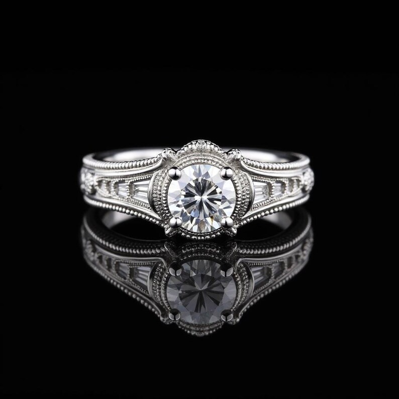 May include: A silver engagement ring with a large, round, clear gemstone at the center. The ring features intricate detailing and smaller, rectangular gemstones on the sides. The ring is set against a black background, with its reflection visible.