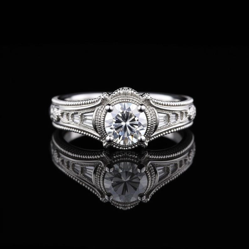 May include: A silver engagement ring with a large, round, clear gemstone at the center. The ring features intricate detailing and smaller, rectangular gemstones on the sides. The ring is set against a black background, with its reflection visible.