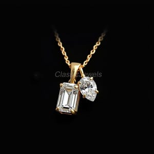 May include: A gold necklace with two diamond pendants. One pendant is an emerald-cut diamond, and the other is a pear-shaped diamond. The necklace is on a black background. The text "Classic Jewels" is visible.