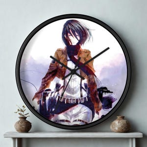 May include: A round wall clock with a black frame. The clock face features an anime-style illustration of a character in a brown jacket, white shirt, and black pants. The clock hands are black.