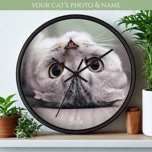 May include: A white ceramic mug with a black handle and the text "But First, Coffee" in a handwritten style. The mug is on a white surface. The mug is approximately 4 inches tall.