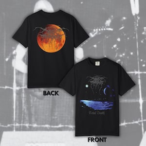 May include: A black short-sleeved t-shirt shown from the front and back. The back features a large orange moon graphic with black text. The front displays a blue landscape with a moon, stars, and the text Darkthrone and Total Death in black.