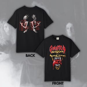 Puede incluir: Una camiseta negra de manga corta mostrada por delante y por detrás. El frente presenta un gráfico de calavera amarilla con el texto rojo SINISTER. La parte posterior muestra dos figuras esqueléticas en blanco y texto rojo con ubicaciones.