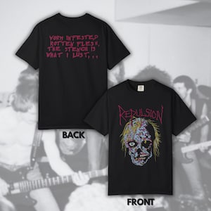 May include: Black t-shirts with front and back designs. The front features a colorful, decaying skull graphic with the word "Repulsion" above it. The back displays the text "Vorm infested rotten flesh, the stench is what I lust..." in pink.