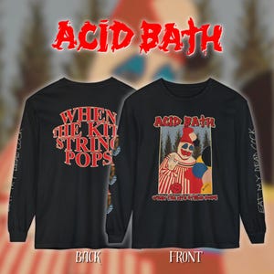Op de afbeelding: Zwart shirt met lange mouwen met de tekst "ACID BATH" in rode, gestileerde letters. De voorkant heeft een clownafbeelding en de tekst "WHEN THE KIT STRING POPS". De achterkant heeft dezelfde tekst. De mouwen hebben de tekst "EAT MY DEAD COCK".