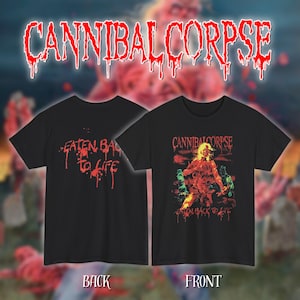 Puede incluir: Camisetas negras con el nombre de la banda "CANNIBAL CORPSE" en fuente roja goteante. Una camiseta tiene "EATEN BACK TO LIFE" en rojo en la espalda. La parte delantera de la otra camiseta tiene un gráfico de una figura en rojo y amarillo.