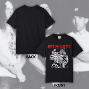 May include: A black short-sleeve t-shirt featuring a graphic print on the front. The design includes the red text RIPPING CORPSE above a black and white illustration of figures performing a medical procedure, with the word BACK and FRONT labeled.