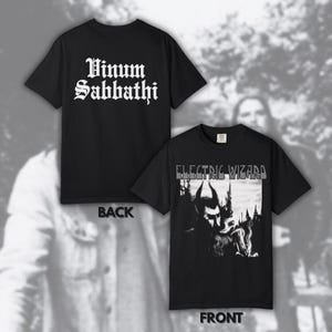 May include: Black t-shirts with white text and graphic designs. One shirt displays "Vinum Sabbathi" on the back. The other shirt features "ELECTRIC WIZARD" and a black and white illustration of a horned figure.