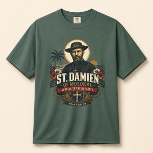 May include: A dark sage green short-sleeve t-shirt featuring a graphic print of St. Damien of Molokai wearing a hat and glasses. The design includes palm trees, hibiscus flowers, a cross, and the text ST. DAMIEN OF MOLOKAI APOSTLE TO THE OUTCASTS PRAY FOR US.