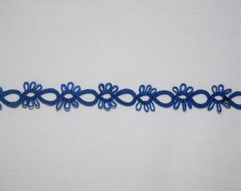 Op de afbeelding: Een stuk blauw kant met een herhalend bloemmotief. Het kant, in een levendige blauwe kleur, staat tegen een witte achtergrond. Het gedetailleerde bloemenpatroon is geschikt voor diverse knutsel- en decoratieprojecten.