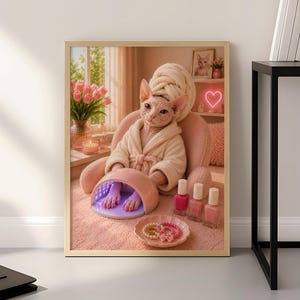 Puede incluir: Una lámina artística enmarcada que muestra un gato Sphynx con un albornoz beige y una toalla a juego en la cabeza. El gato está sentado en una silla rosa, colocando sus patas dentro de una lámpara de uñas UV rosa. Tres esmaltes y un plato con anillos están cerca.