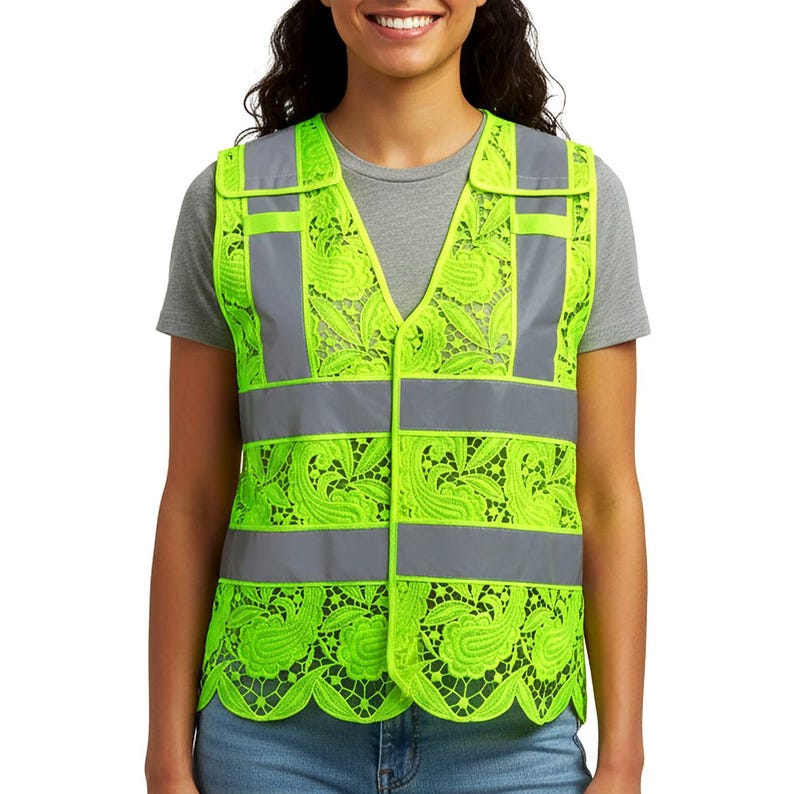 May include: A high-visibility safety vest in neon green with reflective gray stripes and accents. The vest features a decorative lace pattern in the neon green material. The vest has a V-neck and is worn over a gray t-shirt.