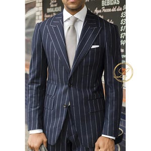 May include: Navy blue pinstripe suit with a white dress shirt and a gray tie. The suit features a two-button closure, a chest pocket, and a tailored fit. The suit is worn with a white pocket square.
